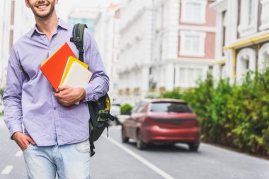 Sokakta ders kitapları ile Mutlu erkek öğrenci