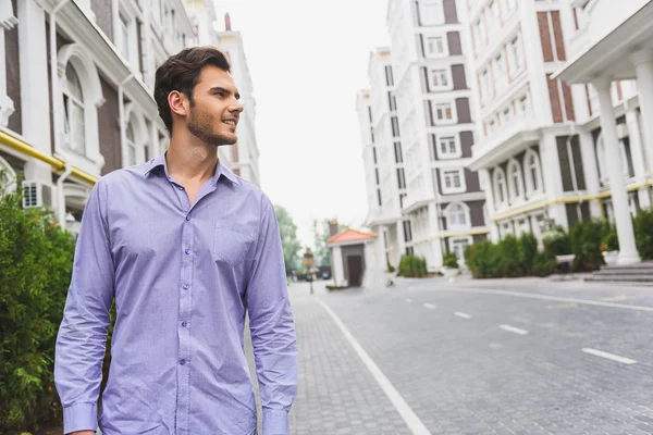 Şehirde yürüyen neşeli işadamı