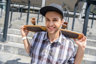 Kaygısız genç adam taşıma kaykay