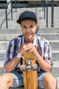 Merdiven üstünde dinlenme neşeli erkek kaykaycı