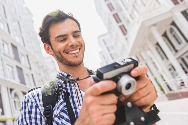 Active male tourist looking at photos