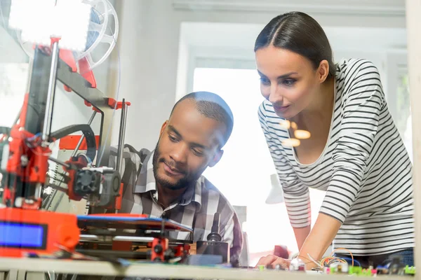 Hombre y mujer inteligentes viendo la impresión 3D —  Fotos de Stock