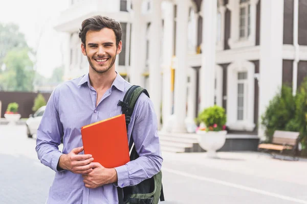 Joyful estudante do sexo masculino posando com livro — Fotografia de Stock