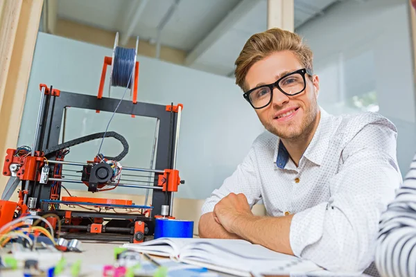 Freudiger junger Mann wartet auf 3D-Druck — Stockfoto