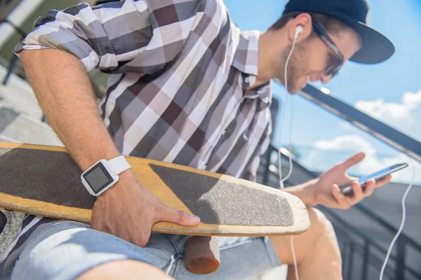 Joyful patinador masculino entretenido con el teléfono —  Fotos de Stock