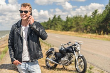 Şık adam motorsikletiyle yanında ayakta