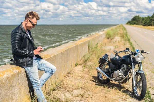 Стильний хлопець стоїть поруч зі своїм мотоциклом — стокове фото