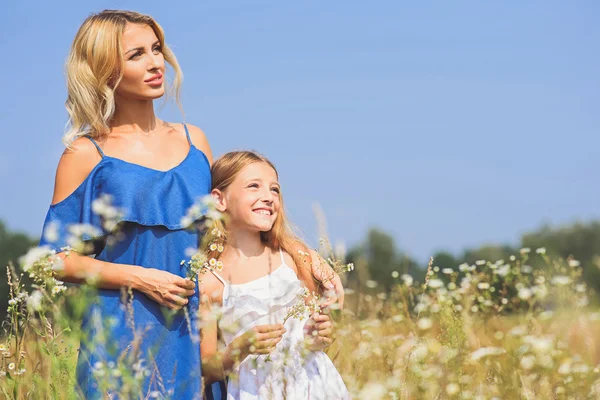 Vacker mor och dotter avkopplande på äng — Stockfoto