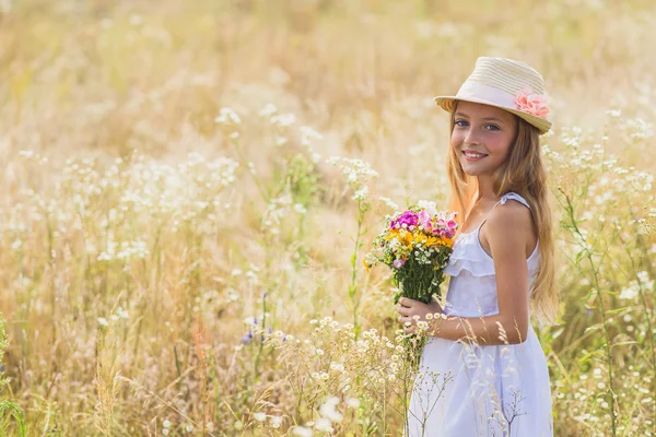 Bambino felice con bouquet sul campo — Foto Stock