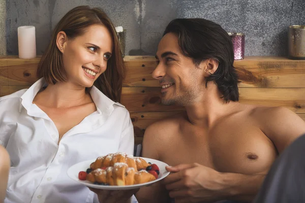 Pareja mirándose mientras sostiene la placa con croissants — Foto de Stock