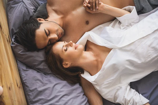 Мужчина и женщина держатся за руки во время сна — стоковое фото