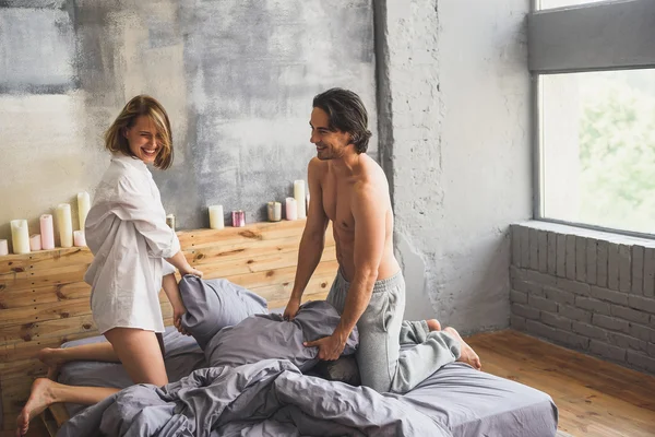 Смішна пара бореться з подушками в ліжку — стокове фото
