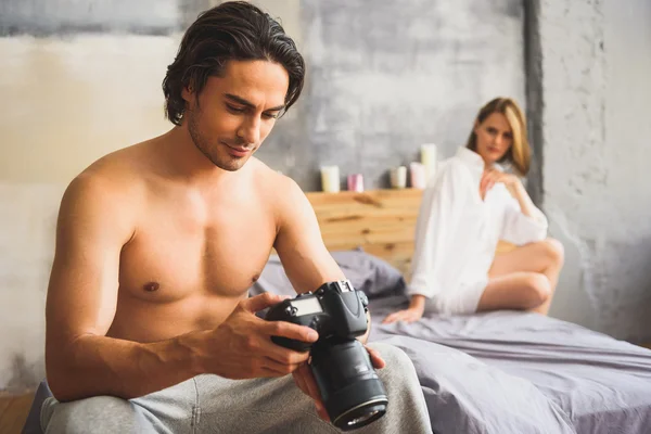 Fotograaf zittend op een bed — Stockfoto