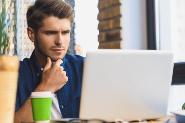 bir dizüstü bilgisayar önünde düşünme genç serbest meslek