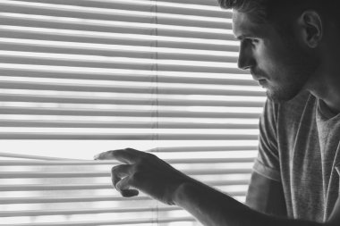 meraklı adam yatay güneşlikler gözlemleyerek