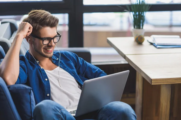 Homem feliz sorrindo na frente do laptop — Fotografia de Stock