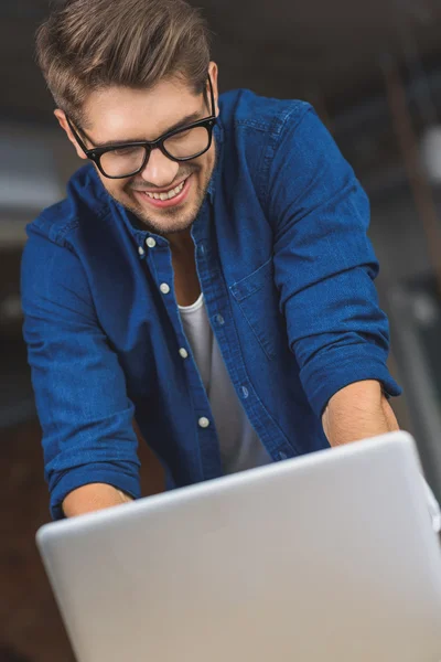 Freelancer em óculos digitando em um laptop — Fotografia de Stock
