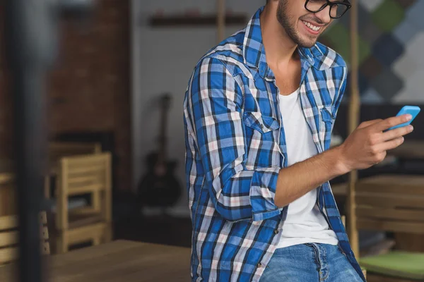 Man använder sin smartphone med leende — Stockfoto