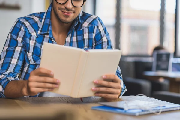 Jonge man genieten van boek bij openbare plaats — Stockfoto