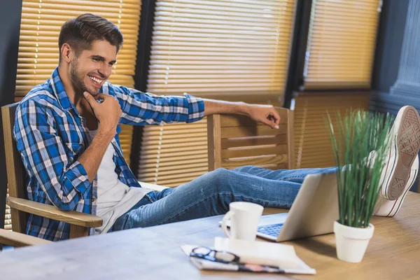 Freelancer avkopplande på kontoret med fötterna på bordet — Stockfoto