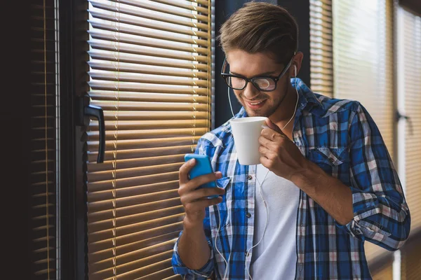 Killen med sin telefon när man dricker kaffe — Stockfoto