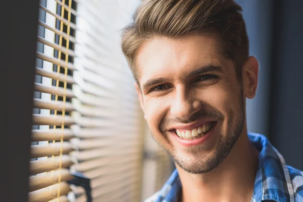 Estudante sorrindo na frente de uma janela — Fotografia de Stock