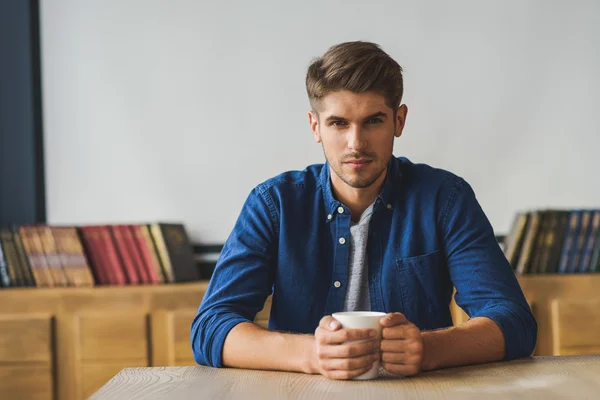 Estudiante sentado en el escritorio y mirando directamente a la cámara — Foto de Stock