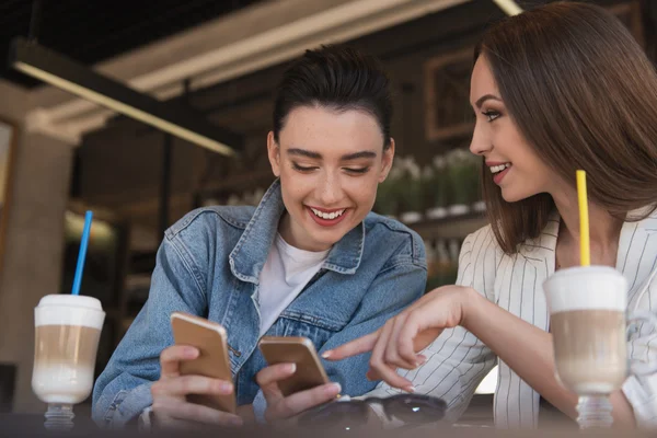 Mulheres amigáveis usando seus smartphones — Fotografia de Stock