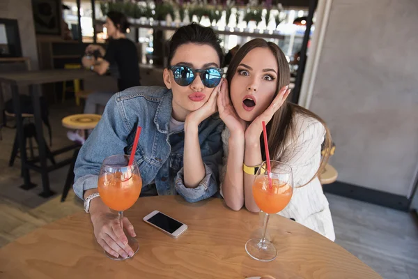 Две веселые девушки сидят в кафе — стоковое фото