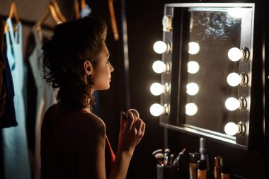 Kendine güvenen kadın model sahne arkasında makyaj yapıyor