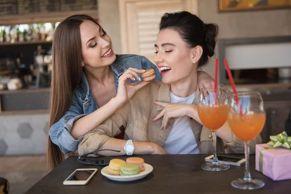 Frauen lachen und essen Kekse — Stockfoto