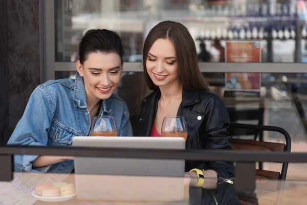 Mujeres viendo algo en un cuaderno — Foto de Stock