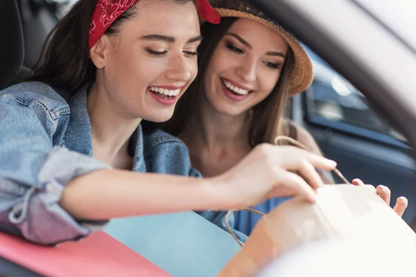 Women sitting in a car with their purchases — Stock Photo, Image