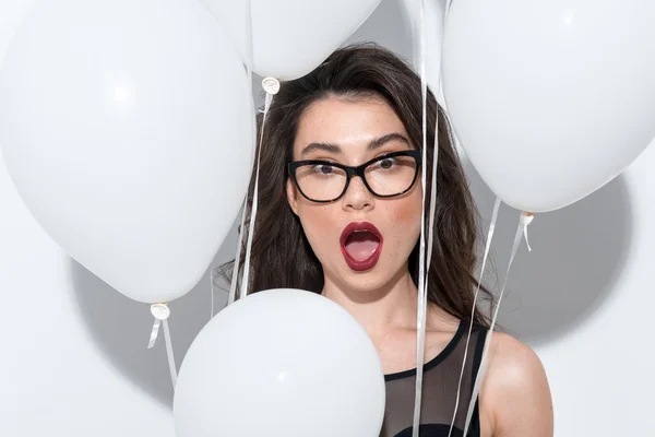 Waist up of a beautiful actress in glasses holding balloons — Stock Photo, Image