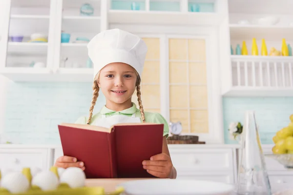 Schattig meisje recept voor het koken lezen — Stockfoto