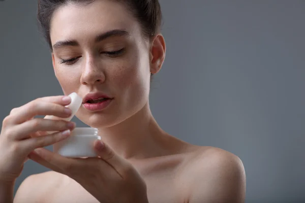 Joven cara femenina relajada sobre fondo gris con espacio para copiar — Foto de Stock