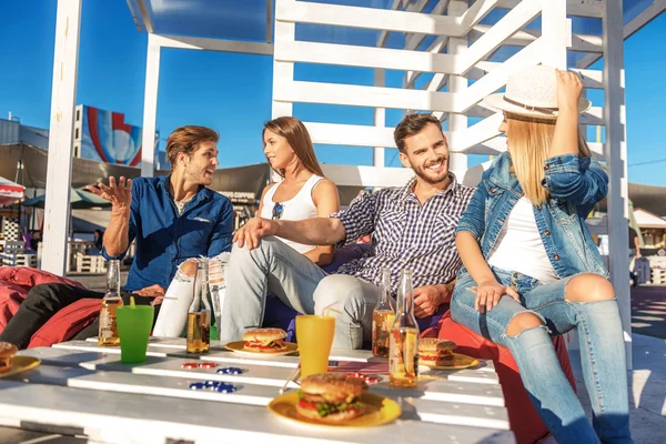 Two couples talking together on the beach — Stock Photo, Image