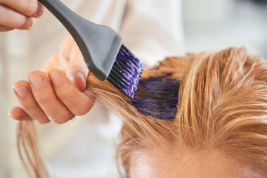 Kuaför fırça kullanıyor.