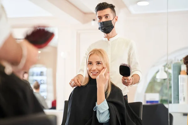 Hairdresser in protective mask calming client — Stock Photo, Image