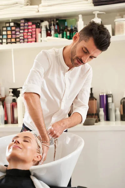Kuaför müşterilerin saçını yıkıyor. — Stok fotoğraf