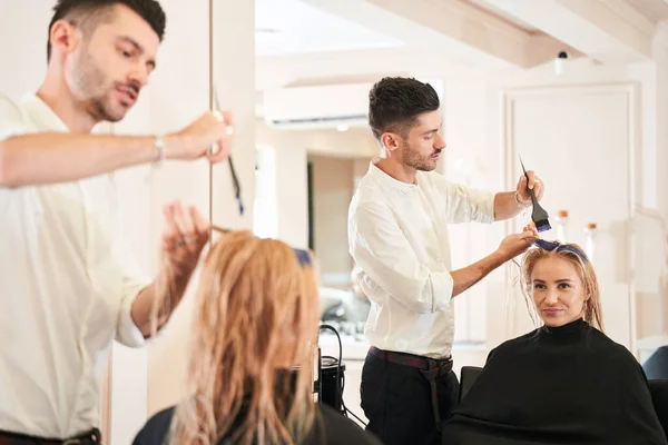 Parrucchiere maschile applicando il colore al cliente femminile — Foto Stock