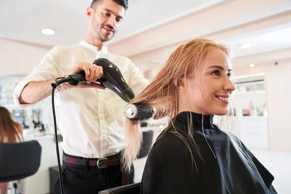 Saç kurutma makinesi ve fırça kullanarak saç stilisti — Stok fotoğraf