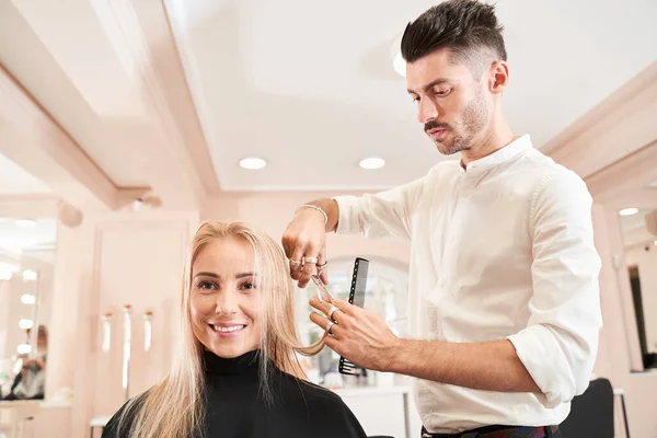 Coiffeur coupe les cheveux du client féminin — Photo