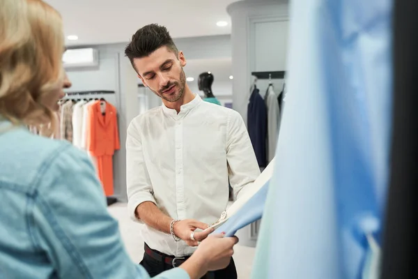 Asistente de cliente y tienda discutiendo calidad de la ropa — Foto de Stock