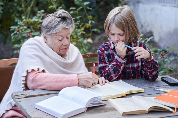 Grand-mère et petit-fils d'âge préscolaire tentent de résoudre une tâche — Photo