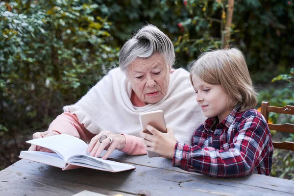 Junge zeigt etwas am Smartphone — Stockfoto