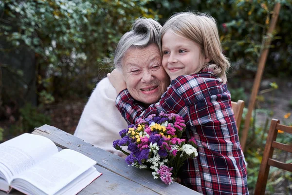 Ребенок обнимает свою седую бабушку — стоковое фото