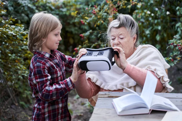 Niño dando gafas VR a su abuela — Foto de Stock