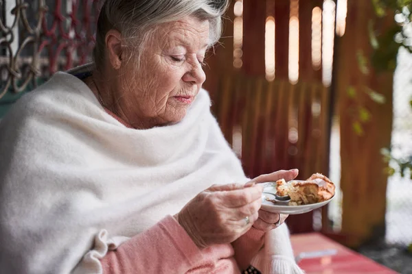 Donna che mangia torta dal piatto — Foto Stock