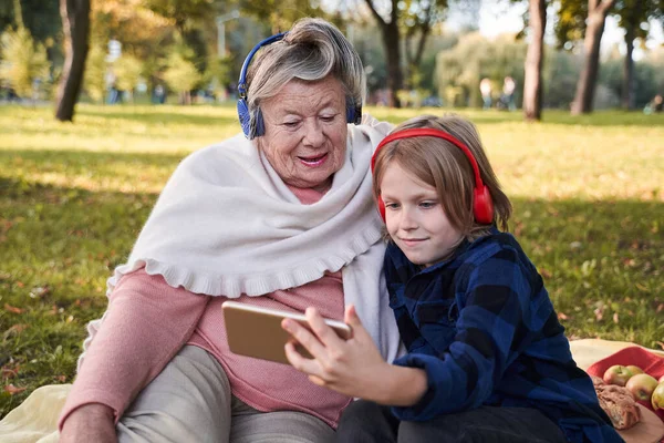 Жінка дивиться мультфільми з онуком — стокове фото
